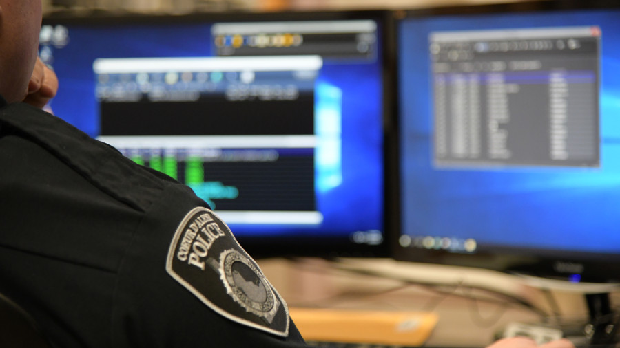 Officer with monitors in background.